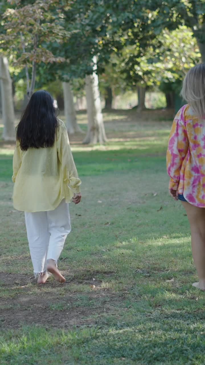 Two Women Walking Barefoot in a Park