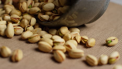 close up shot of pistachio nuts in shells revolving next to bowl 1