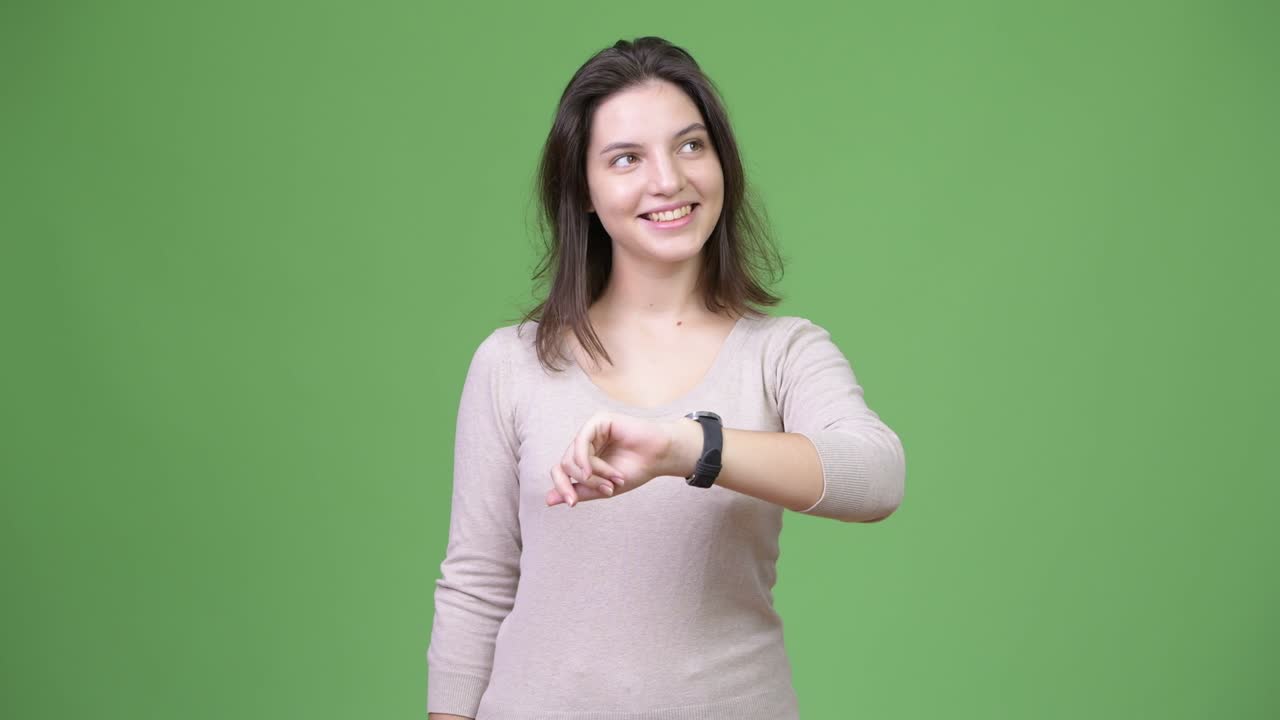 joven feliz mujer hermosa pensando mientras comprueba la hora