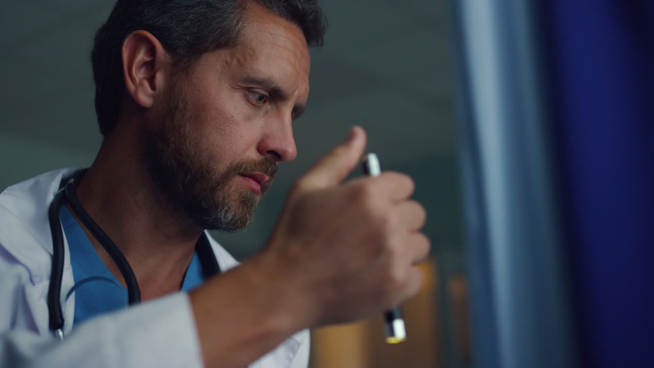 병실 초상화에서 손전등을 사용하는 의사. 직장에서 심각한 의료 전문가