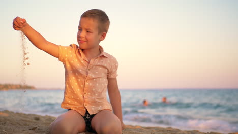 Kind-Spielt-Bei-Sonnenuntergang-Mit-Sand-Am-Meer