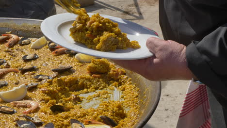 El-Chef-Sirve-Paella-En-Un-Plato.