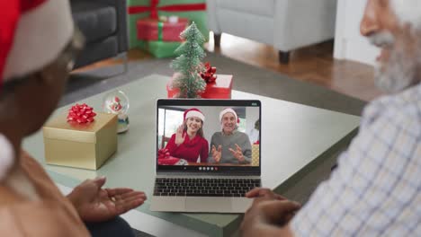 Feliz-Pareja-De-Ancianos-Afroamericanos-En-Videollamada-Con-Amigos-Mayores-En-Navidad