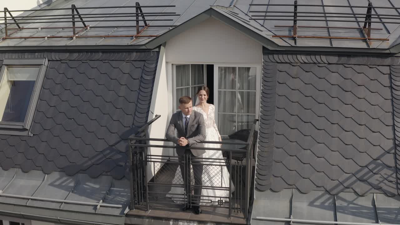 una novia y un novio se besan en un balcón