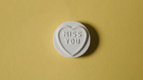 heart candy with miss you message on yellow background