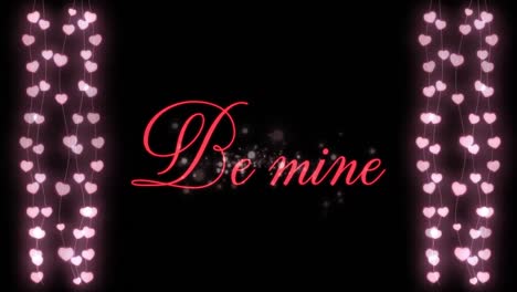 animation of be mine written in red letters with two hearts garlands on black background