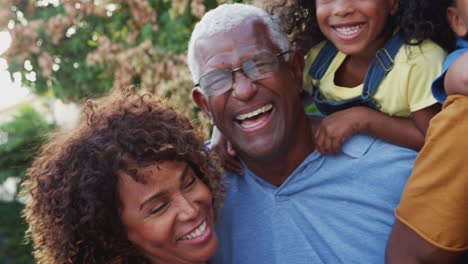 Retrato-De-Una-Familia-Afroamericana-Multigeneracional-Relajándose-Juntos-En-El-Jardín-De-Casa