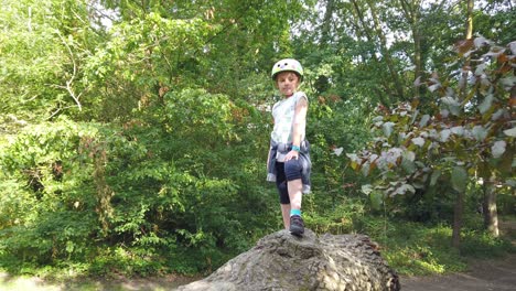 young caucasian girl walking on a large tree trunk in a forest