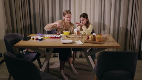 hermanas decorando pan y huevos de pascua