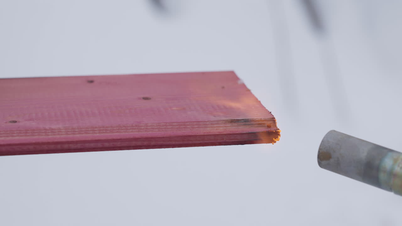 핑크색 나무판의 불타기성을 불로 테스트합니다.