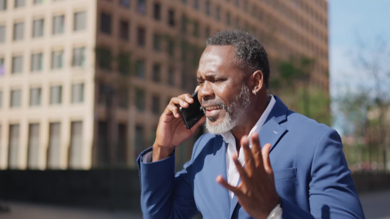 Un uomo in giacca e cravatta che parla al telefono in città