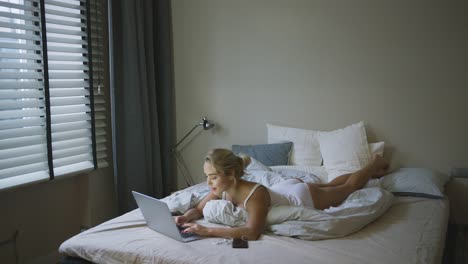 Charming-woman-in-underwear-browsing-laptop