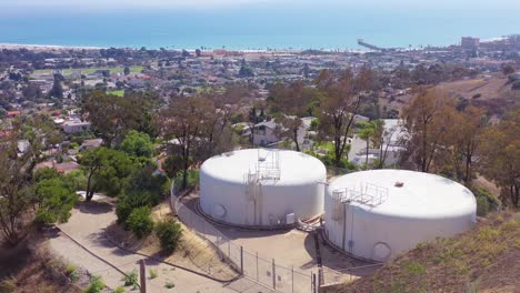 aerial over water tanks high on a hill above the city of ventura california