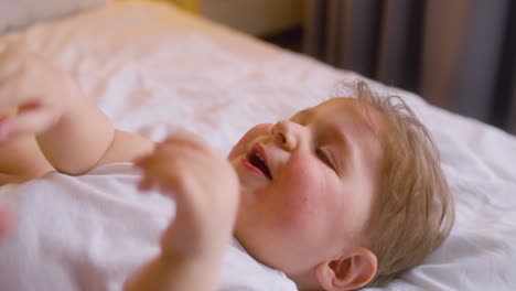 Close-Up-View-Of-A-Baby-Moving-His-Arms-And-Legs-While-His-Mother-Giving-Him-Water-From-Feeding-Bottle