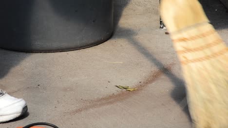 using broom to sweep small line of dirt