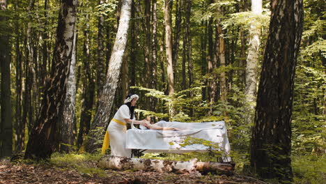 therapist female doctor making woman relaxing spa face massage with hands outdoors in the forest