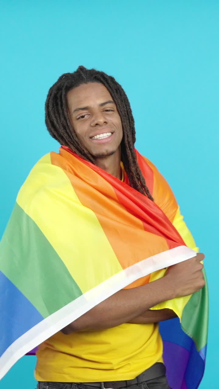 Ritratto di un uomo sorridente con una bandiera arcobaleno