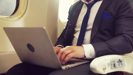 joven empresario que usa una computadora portátil en un avión