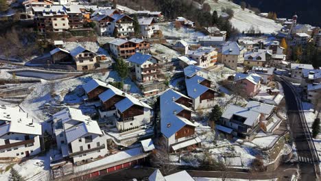 low altitude drone view over the winter village of tiers tires in south tyrol alto adige italy with snowy rooftops narrow roads traditional houses and surrounding meadows
