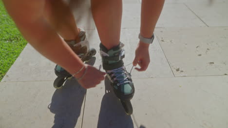 woman lacing roller skates outdoors