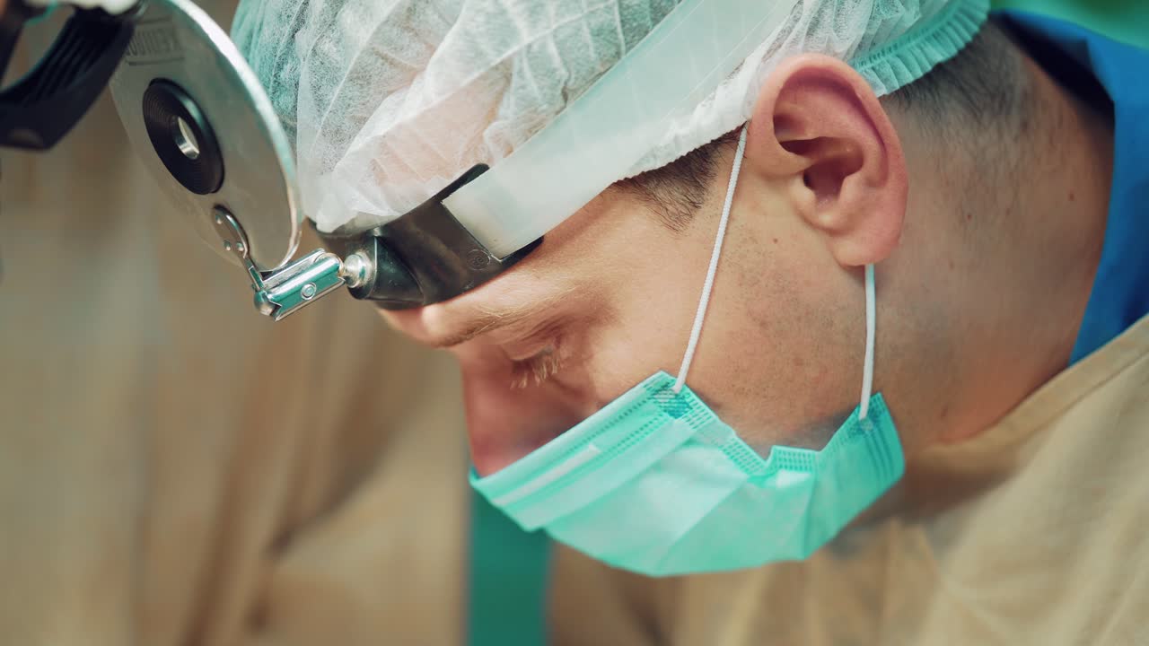In surgery. Doctor wearing protective clothing performing surgery using sterilised equipment