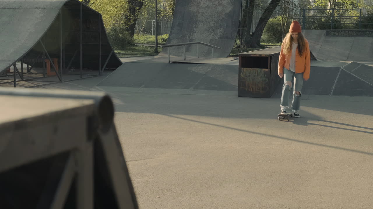 девушка-скейтер поворачивает на рампе на закате в скейт-парке