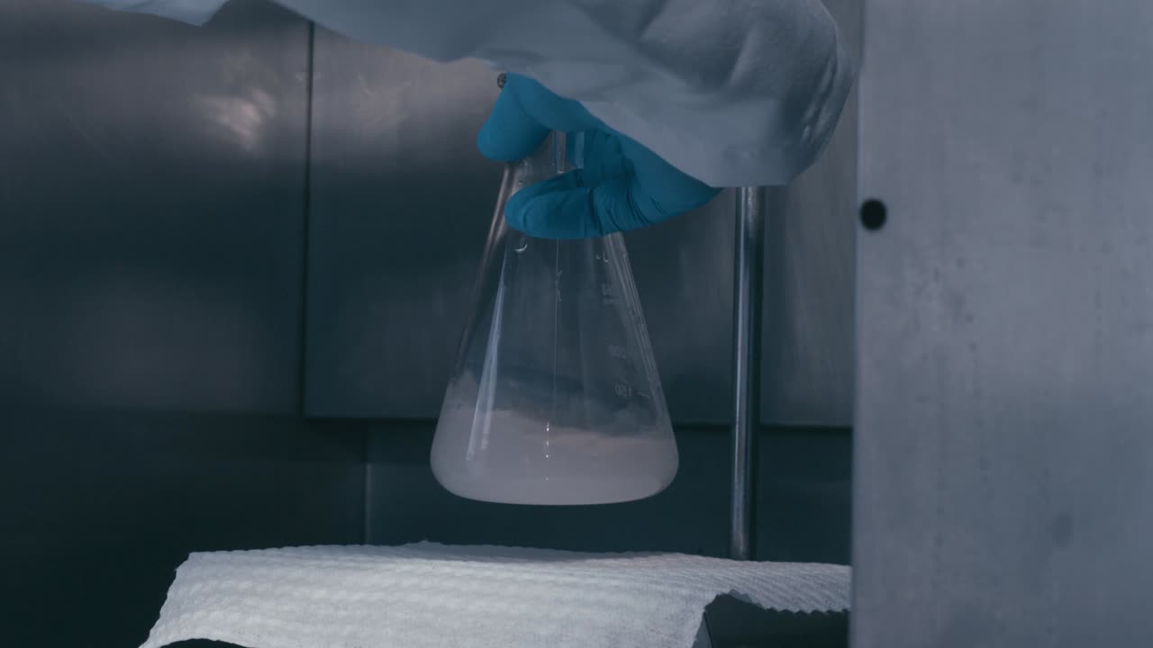 Worker shake a Test Tubes containing chemical liquids while working in a Modern Research Laboratory