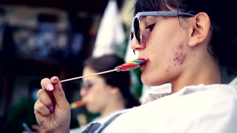 teen girls licking lollipop by the pool