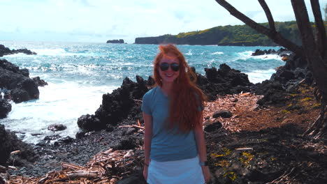 Cute-redhead-girl-waves-and-give-shaka-hang-loose-sign-on-north-shore-of-Maui-on-Road-to-Hana-on-beautiful-Keanae-Peninsula-in-Hawaii-4k-ProRez-HQ
