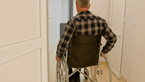 hombre en silla de ruedas en una habitación del hospital