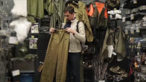 man trying on hunting pants in a sporting goods store