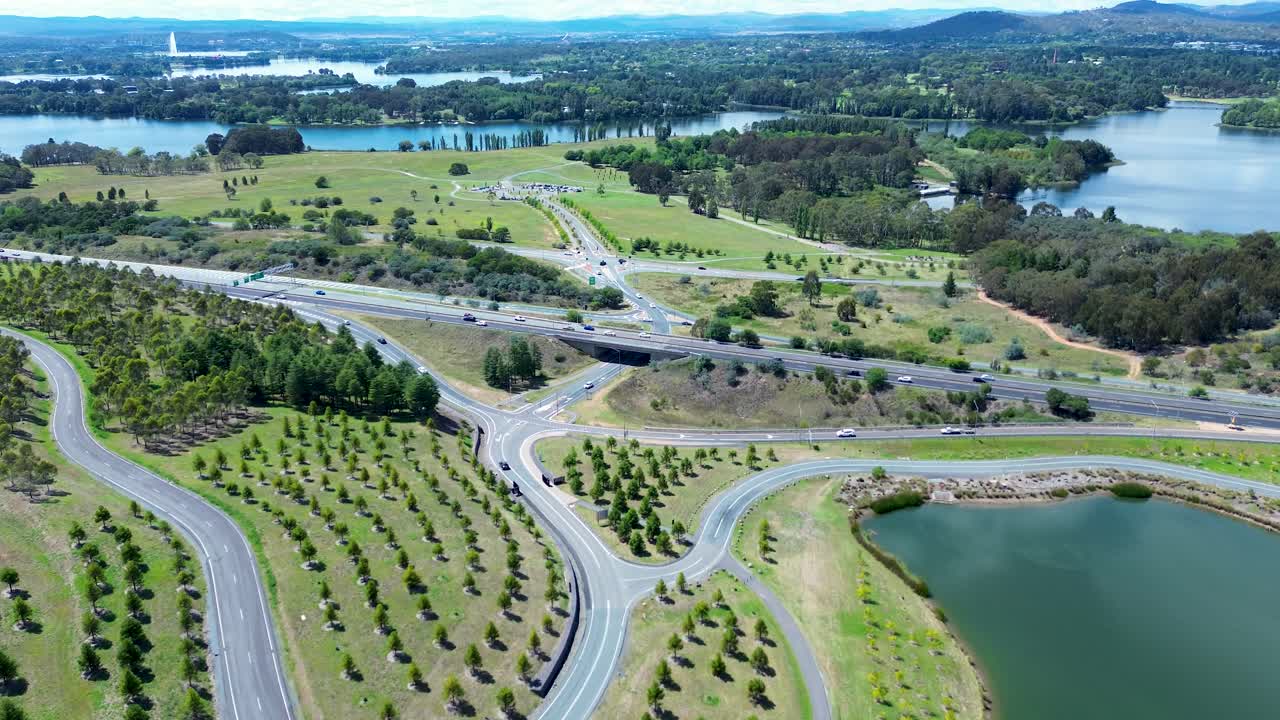 Drone aerial landscape of car vehicles driving across bridge overpass highway road with botanical gardens valley National Arboretum Canberra ACT tourism Australia travel transport holidays