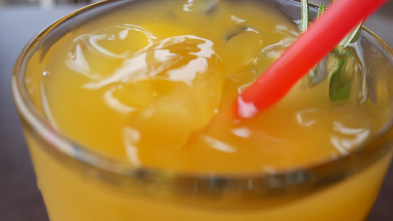 bebida fría de naranja en un vaso grueso de cerca
