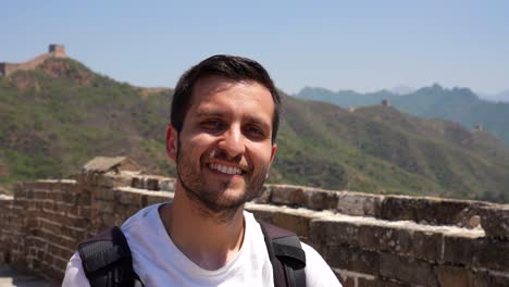 happy backpacker tourist making victory sign in the chinese great wall