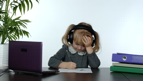 preschool child girl distance online learning at home. kid studying using digital laptop computer