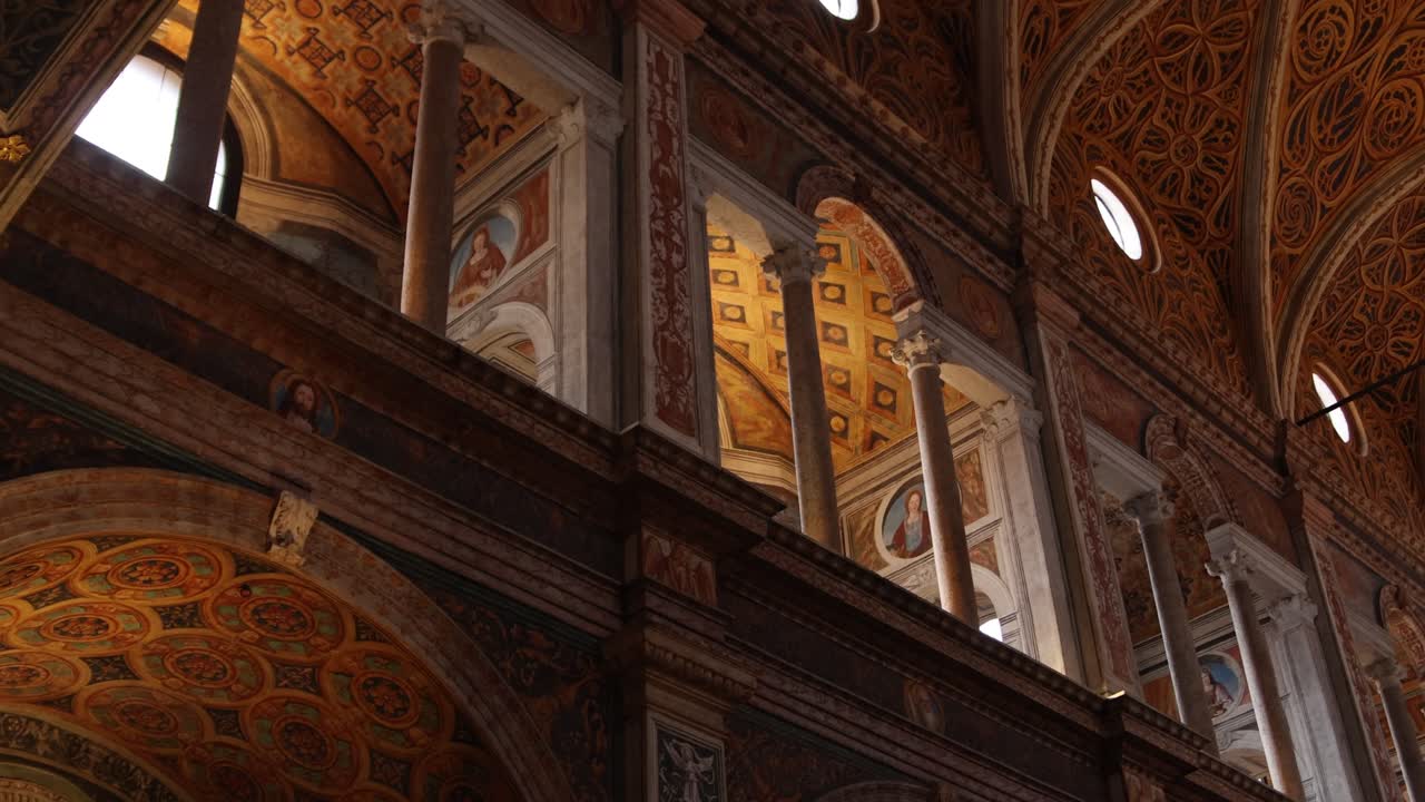 Panoramique ascendant révélant des arches ornées et des plafonds peints dans une grande cathédrale