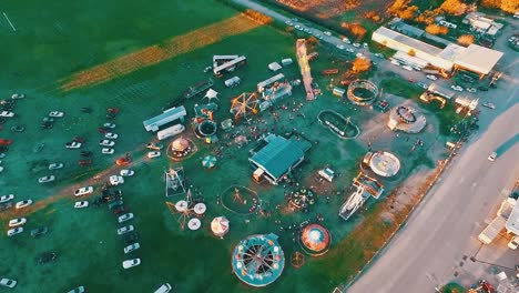 aerial drone footage of a carnival in small town in the sunset with sun rays drawing in the floor