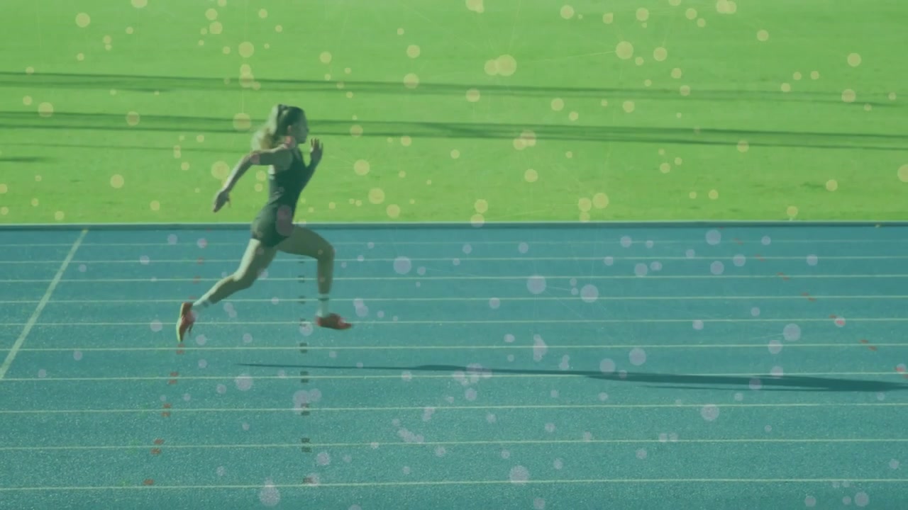 Female sprinter entering blue track accelerating into sprint demonstrating sports technique