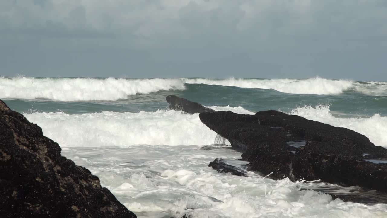 Massive Ocean waves rolling toward shore. Waves crashing into large rocks. Cresmina beach (Praia da Cresmina), Portugal.