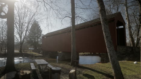winter, static shot with sun flairs of one of three covered bridges in maryland.