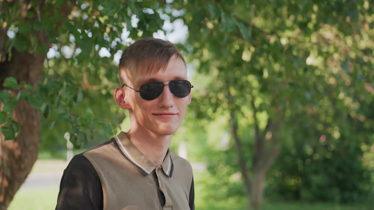 Young Man Examines Phone Outdoors, Casual Profile Picture Of Man Using Phone In Park Setting, Profile Of Smiling Young Man Engaging With His Device Amidst Tranquil Nature Surroundings
