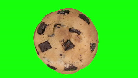 galleta con trocitos de chocolate grande girando sobre fondo verde