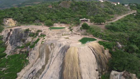 Aerial-of-Hierve-el-Agua,-which-translates-to-"the-water-boils,"-a-series-of-stunning-mineral-laden-rock-formations-that-resemble-cascading-waterfalls,-Mexico