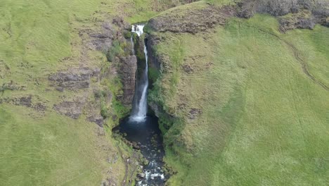 aerial shot of powerful and beautiful waterfall in iceland, wild green lush nature, nature documentary concept cinematic drone footage