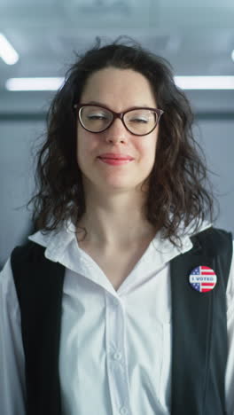 woman in camouflage uniform stands in polling station and looks at camera. portrait of female soldier, united states of america elections voter. background with voting booths. concept of civic duty.