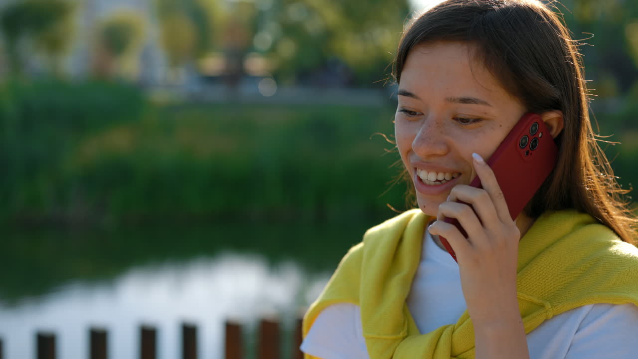 야외에서 전화 통화하는 젊은 여자