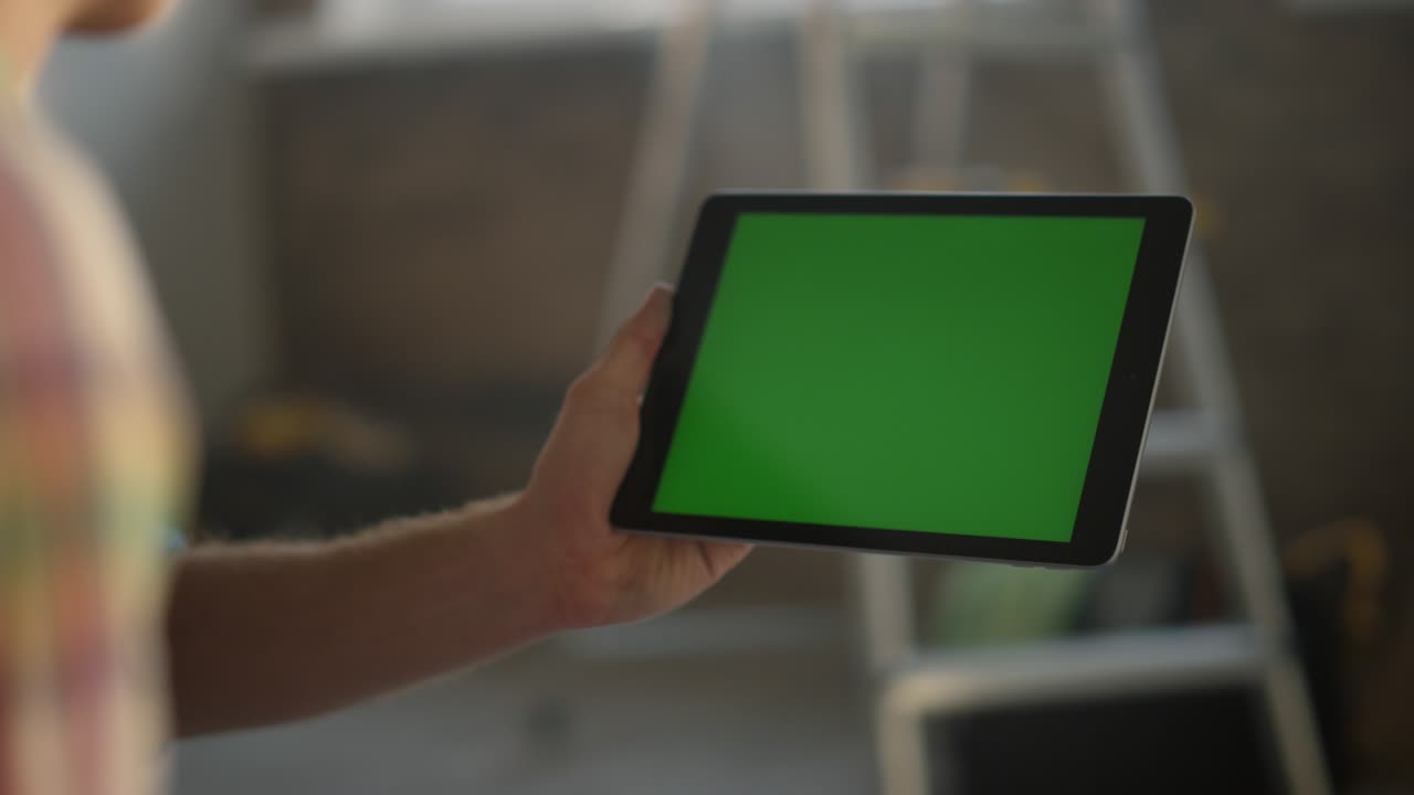 hombre con una tableta en la mano en el interior. tipo desconocido usando un dispositivo moderno para el diseño.