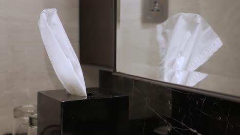 using-hand-taking-pulling-white-facial-tissue-napkin-from-a-black-box-for-clean-handkerchief