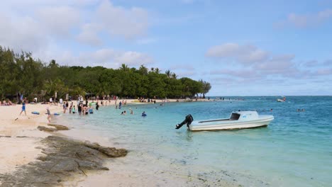 crowded tropical beach with boat