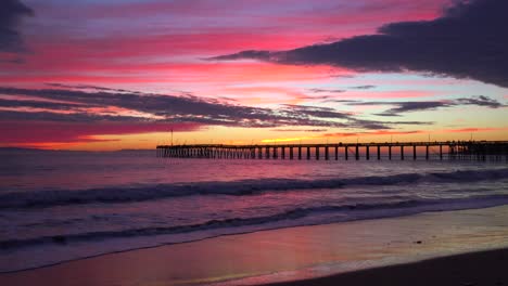 una hermosa costa roja anaranjada al atardecer tomada a lo largo de la costa central de california con el muelle de ventura distante 2